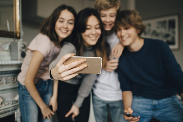 Glückliche Freunde machen ein Selfie mit ihrem Smartphone, während sie zu Hause stehen - MASF00756