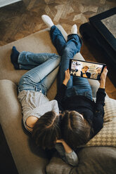 Hochformatige Ansicht von Mädchen, die zu Hause über einen Laptop Videokonferenzen mit Freunden abhalten - MASF00796