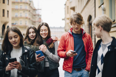 Männliche und weibliche Freunde benutzen Smartphones in der Stadt - MASF00812