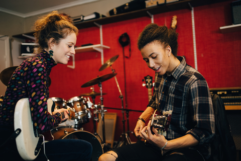 Freunde spielen Gitarren beim Üben im Tonstudio, lizenzfreies Stockfoto