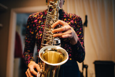 Mittelteil einer Saxophon spielenden Frau beim Üben im Studio - MASF00854