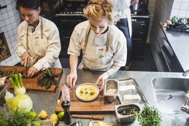 Hoher Blickwinkel auf weibliche Köche, die an der Küchentheke im Restaurant arbeiten - MASF00882