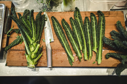 Hohe Winkelansicht von frischen Grünkohlblättern mit Messer auf Schneidebrett im Restaurant Küche - MASF00885