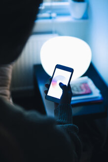 Rear view of teenage girl using smart phone in room at home - MASF00902