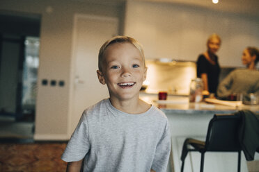 Porträt eines lächelnden Jungen, der vor seiner Familie im Hintergrund steht - MASF00918