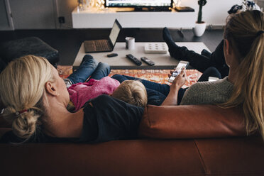 Rückansicht einer Familie auf dem Sofa zu Hause - MASF00929