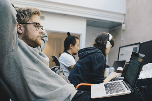 Seitenansicht von Computerprogrammierern bei der Arbeit im Büro - MASF00999