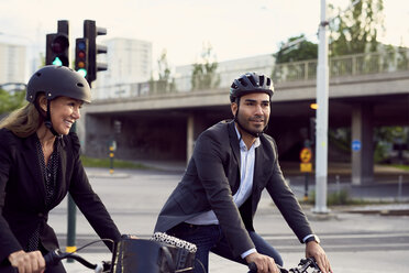 Lächelnde Geschäftskollegen beim Radfahren in der Stadt - MASF01061