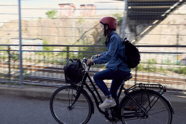 Side view of woman cycling on road in city - MASF01067