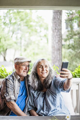 Lächelndes älteres Paar macht Selfie auf der Veranda - MASF01157