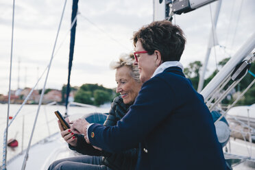 Smiling senior women using mobile phone on yacht - MASF01193