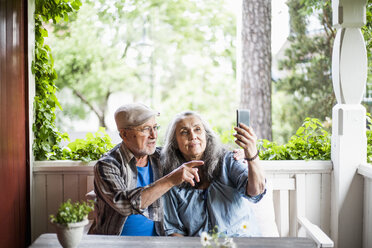 Senior couple taking selfie in porch - MASF01295