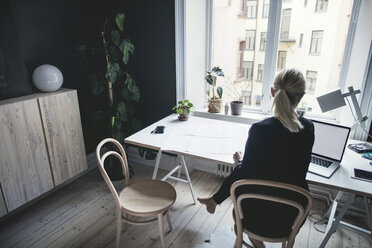 Rückansicht einer Geschäftsfrau bei der Arbeit am Schreibtisch im Heimbüro - MASF01337