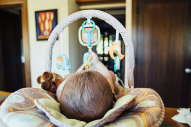Nahaufnahme eines kleinen Jungen, der sich zu Hause in einer Babyschale ausruht - CAVF35171