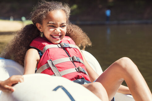 Glückliches Mädchen sitzt in Tretboot auf sonnigen Tag - CAVF35209
