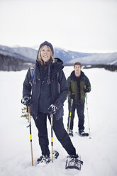 Portrait of woman with her adult son snowshoeing - CAVF35274