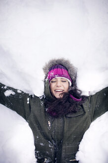 Junge Frau im Schnee liegend - CAVF35308