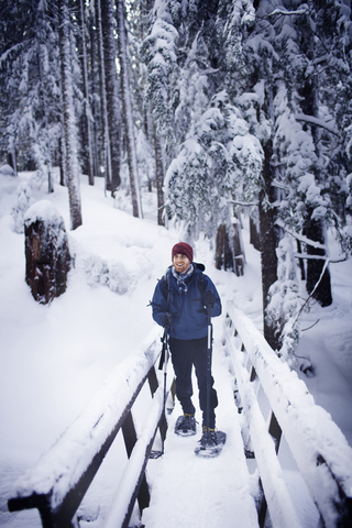 Junger Wanderer auf einer Fußgängerbrücke im Winter, lizenzfreies Stockfoto