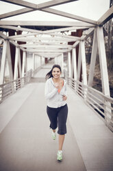 Woman running on bridge - CAVF35382