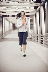 Woman running on bridge - CAVF35383