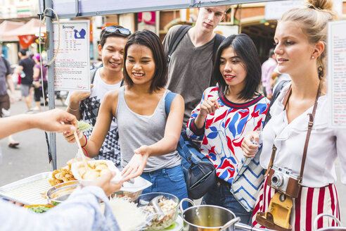Thailand, Bangkok, Khao San Road, Gruppe von Freunden, die auf einem Straßenmarkt einheimisches Essen probieren - WPEF00201