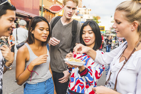 Thailand, Bangkok, Khao San Road, Gruppe von Freunden, die auf einem Straßenmarkt einheimisches Essen probieren - WPEF00203