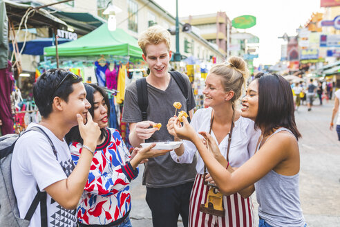 Thailand, Bangkok, Khao San Road, Gruppe von Freunden, die auf einem Straßenmarkt einheimisches Essen probieren - WPEF00205