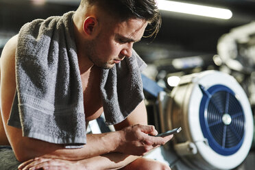 Man using cell phone at the gym - ABIF00243