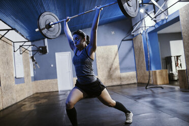 Woman lifting barbell in gym - ZEDF01262