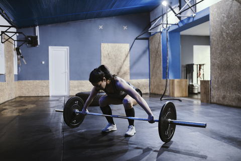 Woman preparing for weightlifting in gym stock photo