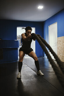 Frau trainiert mit Seilen im Fitnessstudio - ZEDF01269