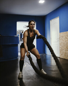Frau trainiert mit Seilen im Fitnessstudio - ZEDF01271