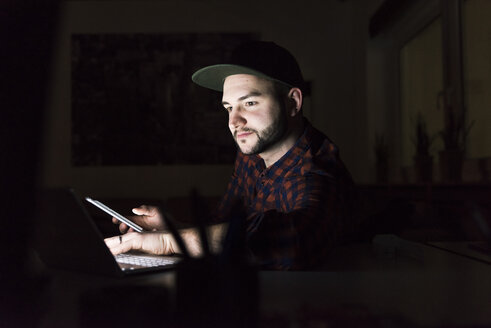 Porträt eines Freiberuflers, der noch spät am Laptop arbeitet - UUF13241