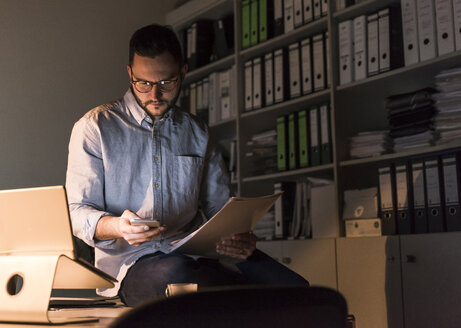 Geschäftsmann arbeitet lange im Büro - UUF13248