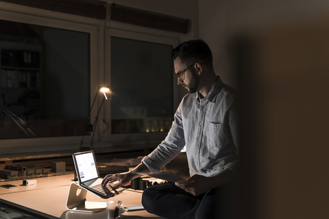 Geschäftsmann arbeitet lange im Büro, lizenzfreies Stockfoto