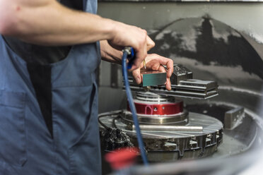 Nahaufnahme eines Mannes bei der Arbeit an einer Maschine in einer Fabrik - DIGF03656