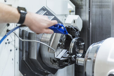 Close-up of man working at machine in factory - DIGF03663