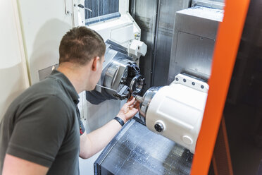 Man working at machine in factory - DIGF03665