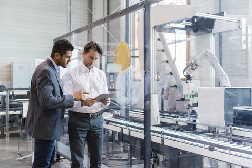 Two businessmen with tablet talking in modern factory - DIGF03690