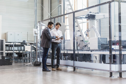 Two businessmen with tablet talking in modern factory - DIGF03691