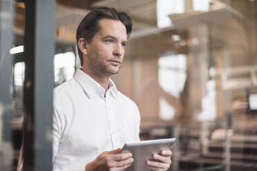 Businessman with tablet in factory thinking - DIGF03696