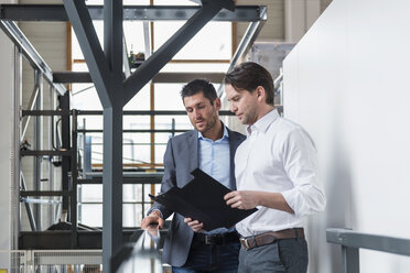 Two businessmen with clipboard talking in factory - DIGF03708