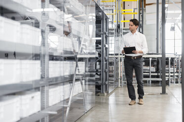 Man with clipboard in modern factory - DIGF03713