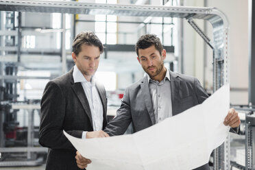 Two businessmen looking at plan in modern factory - DIGF03726