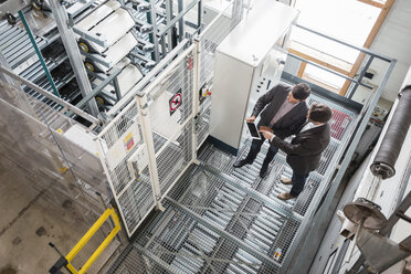 Two businessmen with tablet talking in modern factory - DIGF03737