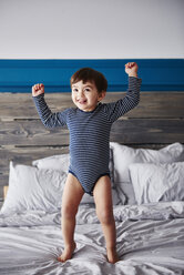 Portrait of happy toddler jumping on bed - ABIF00275