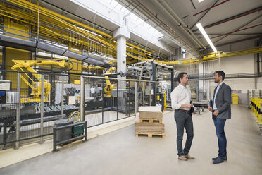 Two businessmen talking on factory shop floor - DIGF03751