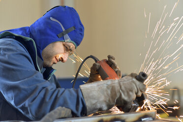 Arbeiter mit Winkelschleifer in einer Fabrik - LYF00806