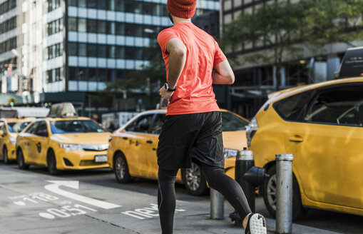 USA, New York City, Mann läuft in der Stadt mit Daten auf dem Bürgersteig - UUF13262