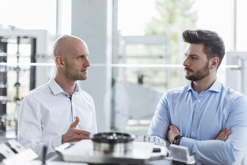 Zwei Männer diskutieren über ein Produkt in einem Unternehmen - DIGF03785